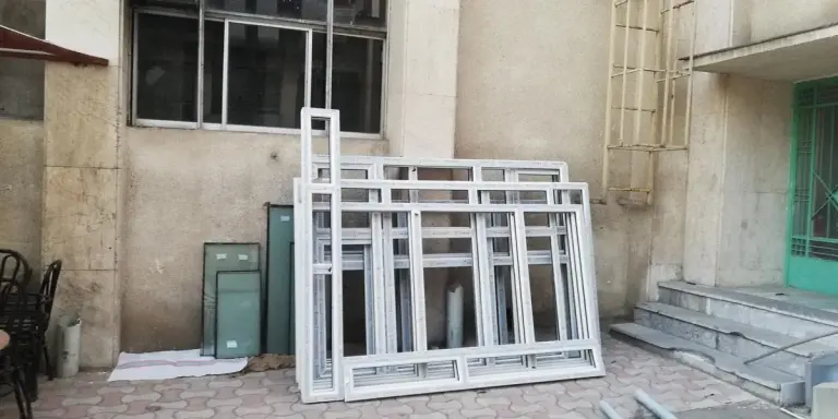 قابهای پنجره UPVC چیدهشده کنار ساختمان