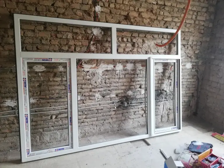 پنجره بزرگ سهلنگه UPVC در دیوار آجری، هنوز با فیلم محافظ