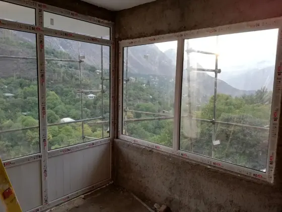 پنجره‌های دوجداره UPVC در گوشه یک ویلا، رو به دره و کوه